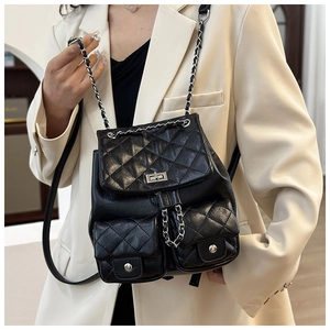 Détail du sac à dos en cuir noir matelassé avec chaînes métalliques et poches avant