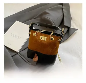 Detail of kids bucket bag featuring brown suede and black quilted leather with chain
