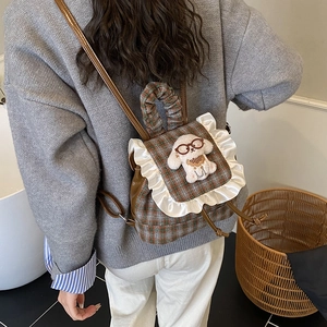 Checkered children backpack with white lace trim and cute plush puppy charm