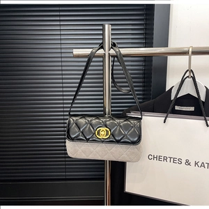 Detailed shot of two-tone quilted leather crossbody bag with gold-tone ring magnetic clasp