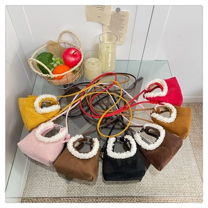 Macro detail of various suede dumpling bags featuring plush white lamb wool handles