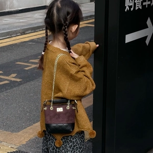 Kid bucket bag in brown matte texture with gold chain strap shown on child model