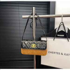 Detail of two-tone quilted crossbody bag with gold metal ring lock and contrast textures