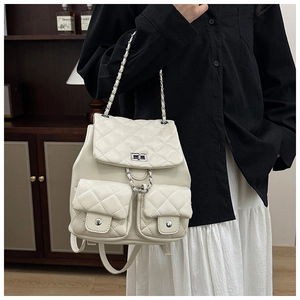 Détail d'un sac à dos blanc en cuir matelassé avec des bretelles en chaîne
