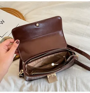 Detailed interior of a brown leather shoulder bag with multiple storage compartments