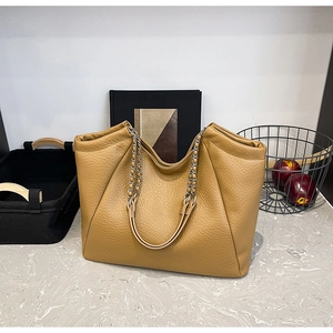 Close-up of litchi pattern faux leather tote bag with metallic chain and leather straps