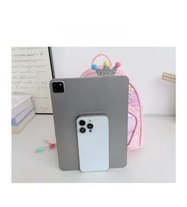 Pink sequin mini backpack size comparison with a tablet and smartphone next to a crown charm