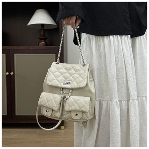 Détails d'un sac à dos matelassé beige avec ferrures argentées et chaînes