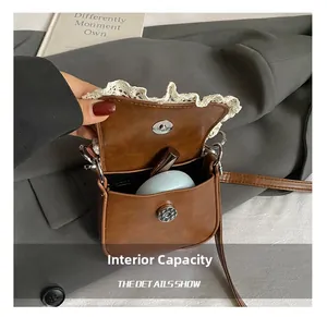 Internal capacity of mini brown PU crossbody bag showing lace edge and metal magnetic clasp