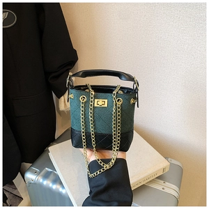 Detail of green suede bucket bag with diamond stitching and gold chain strap
