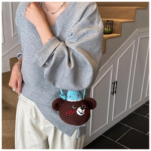 Detail of handmade crochet bear mini bag with blue hat and cute 3D ears