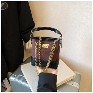 Detail of kids bucket bag featuring brown suede stitching and black quilted leather patterns