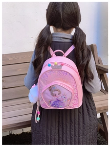Detail of pink sequin kids backpack with cute cartoon princess and unicorn charms