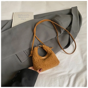 Détail d'un sac bandoulière en peluche marron avec fine sangle sur fond chaleureux de style bohème