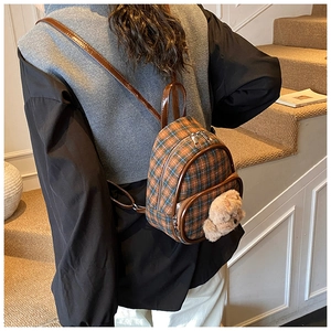 Mini plaid backpack for kids with a cute plush bear charm shown on model's back