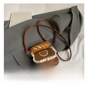 Detail view of brown PU leather crossbody bag featuring white lace trim and bear embroidery