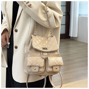 Vue détaillée du sac à dos en cuir matelassé beige avec fermoir argenté et chaîne