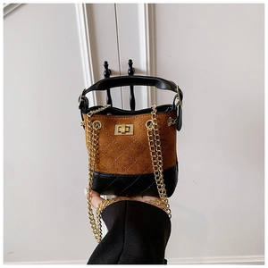 Macro shot of children's mini bucket bag with quilted leather and golden lock buckle