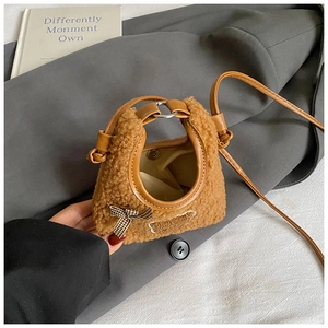 Détail d'un sac en peluche marron avec un petit nœud à carreaux et un fermoir magnétique