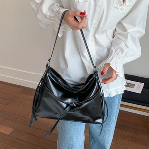 Large capacity black PU leather tote bag for women with tassel detail in a minimalist design