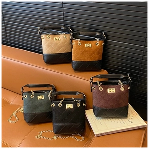 Detailed shot of five mini bucket bags in assorted colors with quilted stitching and gold chain