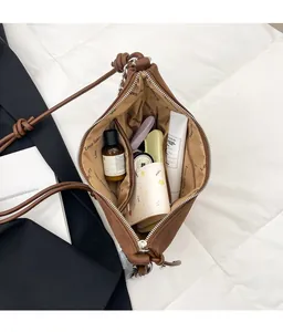 Top view of spacious brown leather bag interior showing cosmetics and branded lining