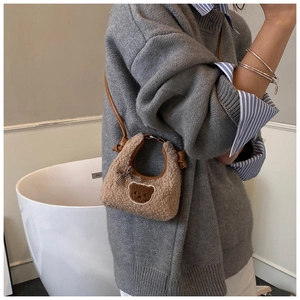 Sac bandoulière en peluche marron avec écusson ours et nœud sur un mannequin