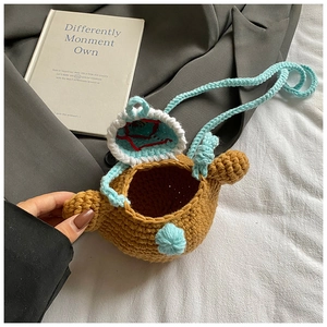 Detailed overhead view of a handmade brown knitted bear crossbody bag for children