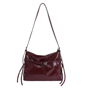 Glossy burgundy PU leather tote bag with silver buckle and tassel details on white background