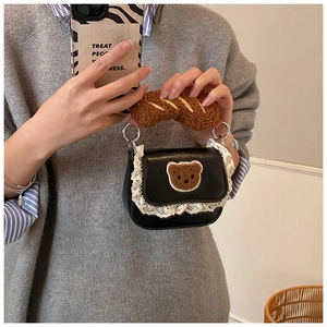 Detailed shot of black mini bag with lace trim and plush baguette shaped handle