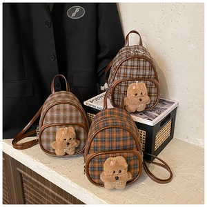 Detail of British style plaid mini backpacks with cute plush puppy and leather trim