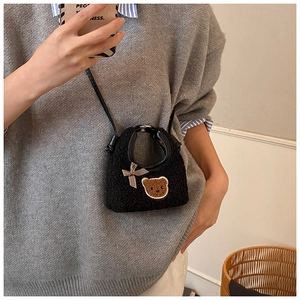Détail du mini sac peluche noir avec ours brodé et nœud à carreaux pour fille