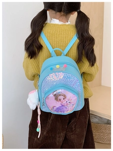 Detail view of blue sequin kids backpack with princess pattern and plush bunny pendant