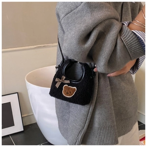 Détail d'un sac en peluche noir pour fille avec broderie ours et nœud à carreaux