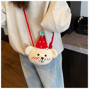 Close-up of handmade crochet bear mini crossbody bag for kids with red party hat