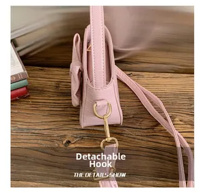 Pink faux crocodile leather bag detail with detachable gold hook and ribbon bow