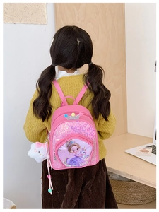 Pink sequin children backpack with crown and unicorn print worn by a toddler model