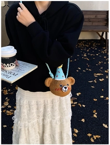 Detail of handmade crochet bear crossbody bag featuring party hat and knit texture