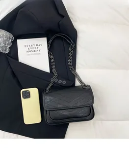 Detail of black V-quilted leather hobo bag with a matching metal chain strap