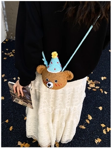 Detail of a handmade brown crochet bear crossbody bag worn with an autumn outfit