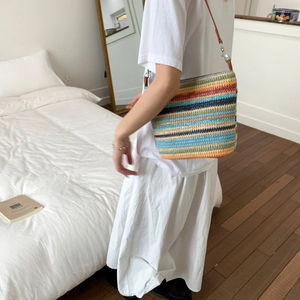 Borsa a tracolla all'uncinetto arcobaleno con cinturino in pelle in un ambiente moderno