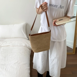 Elegante borsa a secchiello intrecciata in paglia beige con tracolla in finta pelle marrone