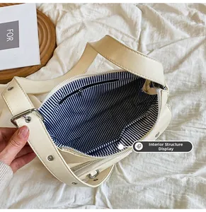 Internal view of beige faux leather bag with blue striped lining and zipper pocket