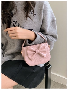 Detailed macro of pink crocodile pattern leather bag with a stylish bow decoration