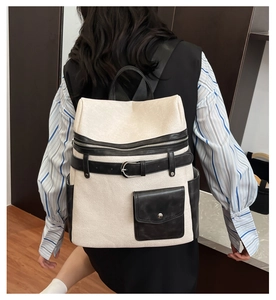 Detail view of the beige PU leather backpack with black decorative belt and buckle