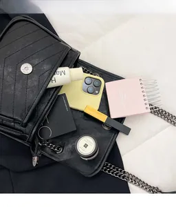 Detail of black quilted chain bag showing interior storage capacity and chic metal hardware