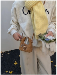 Détail du mini sac peluche marron avec motif ourson et nœud à carreaux sur un mannequin