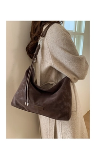 Close-up of brown suede Hobo bag with metallic brand logo and silver hardware details