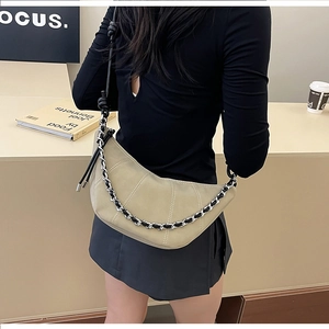 Detail of khaki suede half-moon bag with contrast stitching and metal chain strap