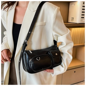 Detail of a black industrial style underarm bag with silver hardware and utility pockets